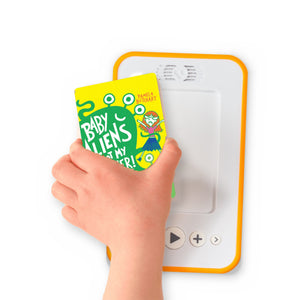 A hand holding the audiobook card for Baby Aliens Got My Teacher beside a Voxblock audiobook player