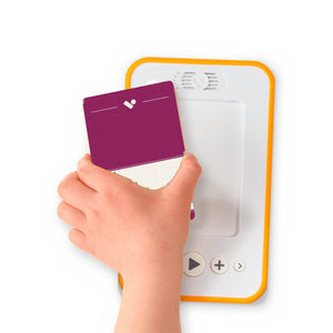 A hand holding the audiobook card for Emma beside a Voxblock audiobook player