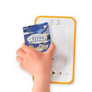 A hand holding the audiobook card for Explorers on Witch Mountain beside a Voxblock audiobook player
