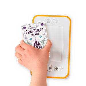 A hand holding the audiobook card for Fairy Tales For You beside a Voxblock audiobook player