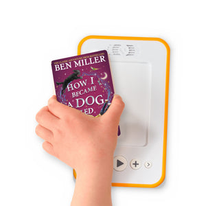 A hand holding the audiobook card for How I Became a Dog Called Midnight beside a Voxblock audiobook player