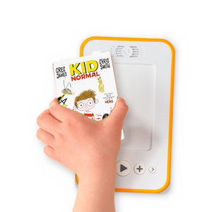 A hand holding the audiobook card for Kid Normal beside a Voxblock audiobook player