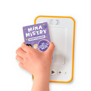 A hand holding the audiobook card for Mina Mistry Investigates: The Case of the Disappearing Pets beside a Voxblock audiobook player