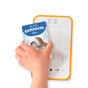 A hand holding the audiobook card for My First Beethoven Album beside a Voxblock audiobook player