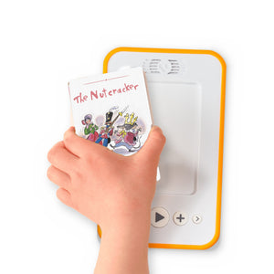 A hand holding the audiobook card for The Nutcracker and Christmas Eve beside a Voxblock audiobook player