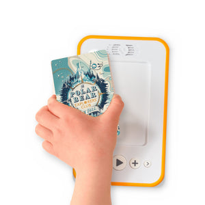 A hand holding the audiobook card for The Polar Bear Explorers' Club beside a Voxblock audiobook player