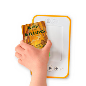 A hand holding the audiobook card for The Wind in the Willows beside a Voxblock audiobook player