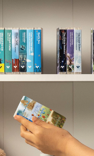 A hand taking the Relax at the Beach + The Enchanted Garden + The Magic Butterfly audiobook from a shelf of Voxblock audiobooks
