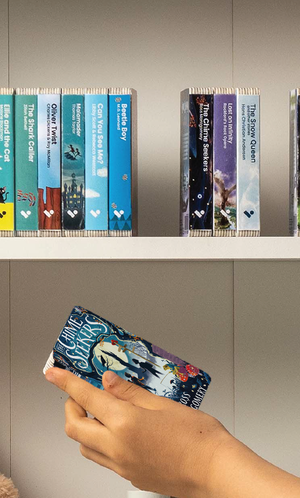 A hand taking The Chime Seekers audiobook from a shelf of Voxblock audiobooks