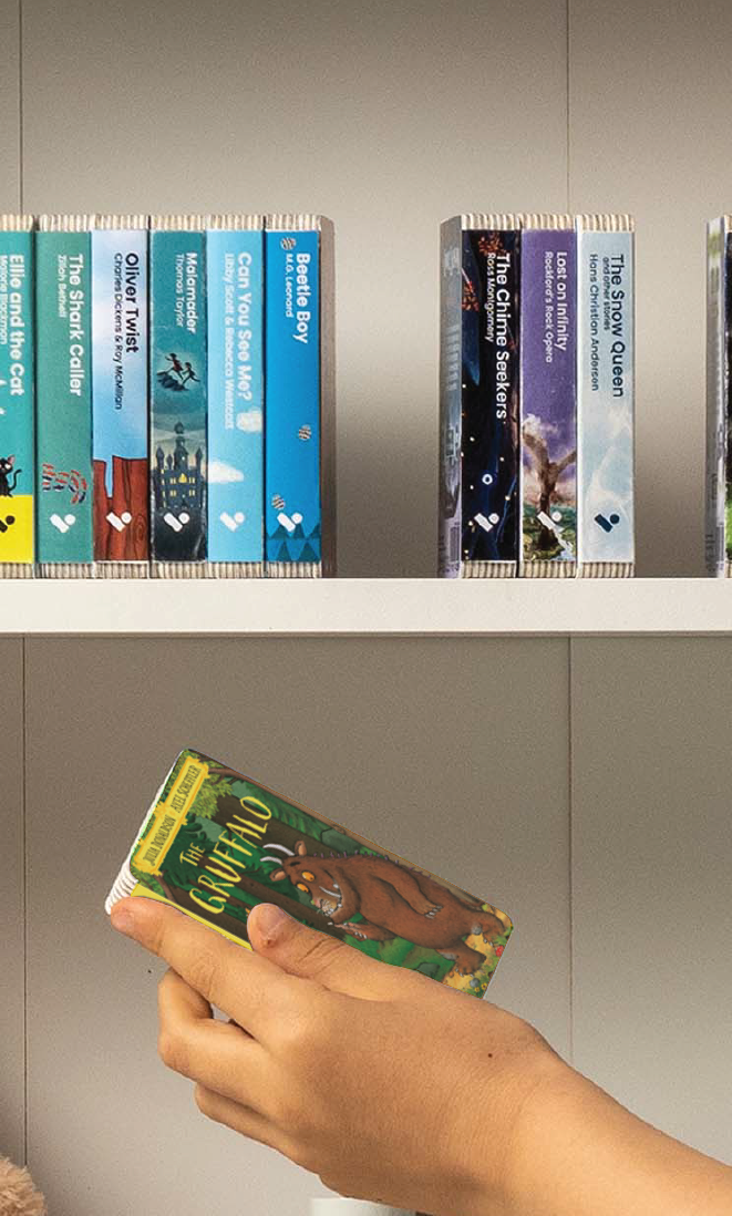A hand taking The Gruffalo audiobook from a shelf of Voxblock audiobooks