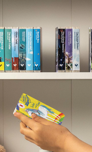 A hand taking the Unicorn Academy: Isabel and Cloud audiobook from a shelf of Voxblock audiobooks