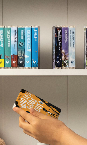 A hand taking the Who Let the Gods Out? audiobook from a shelf of Voxblock audiobooks