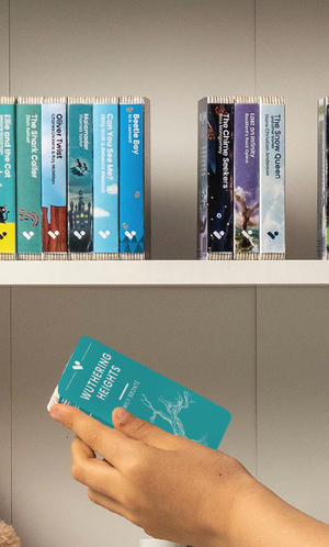 A hand taking the Wuthering Heights audiobook from a shelf of Voxblock audiobooks
