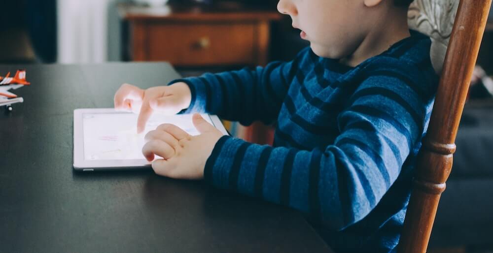 A child looks at an iPad screen.