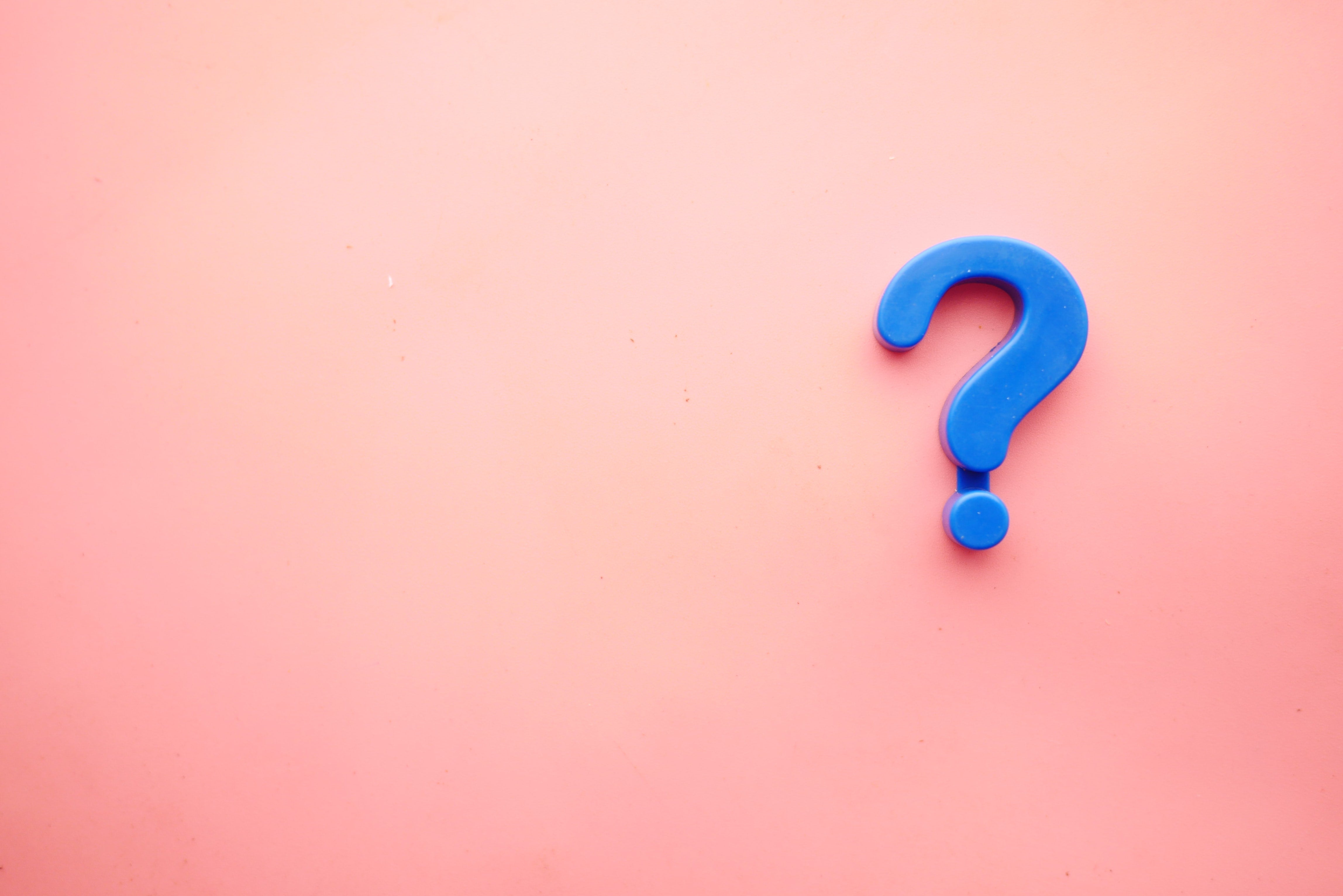 Blue question mark on a pink background.