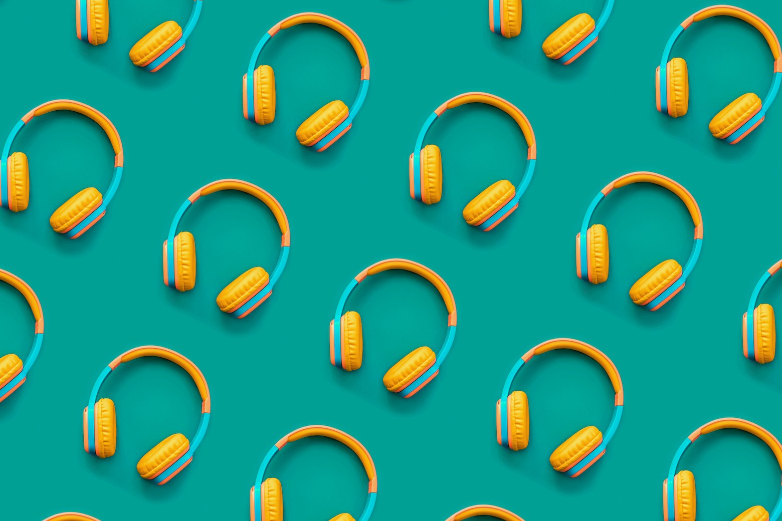 Listen to audiobooks. Blue and orange headphones laid out in a repeating pattern on a turquoise background.