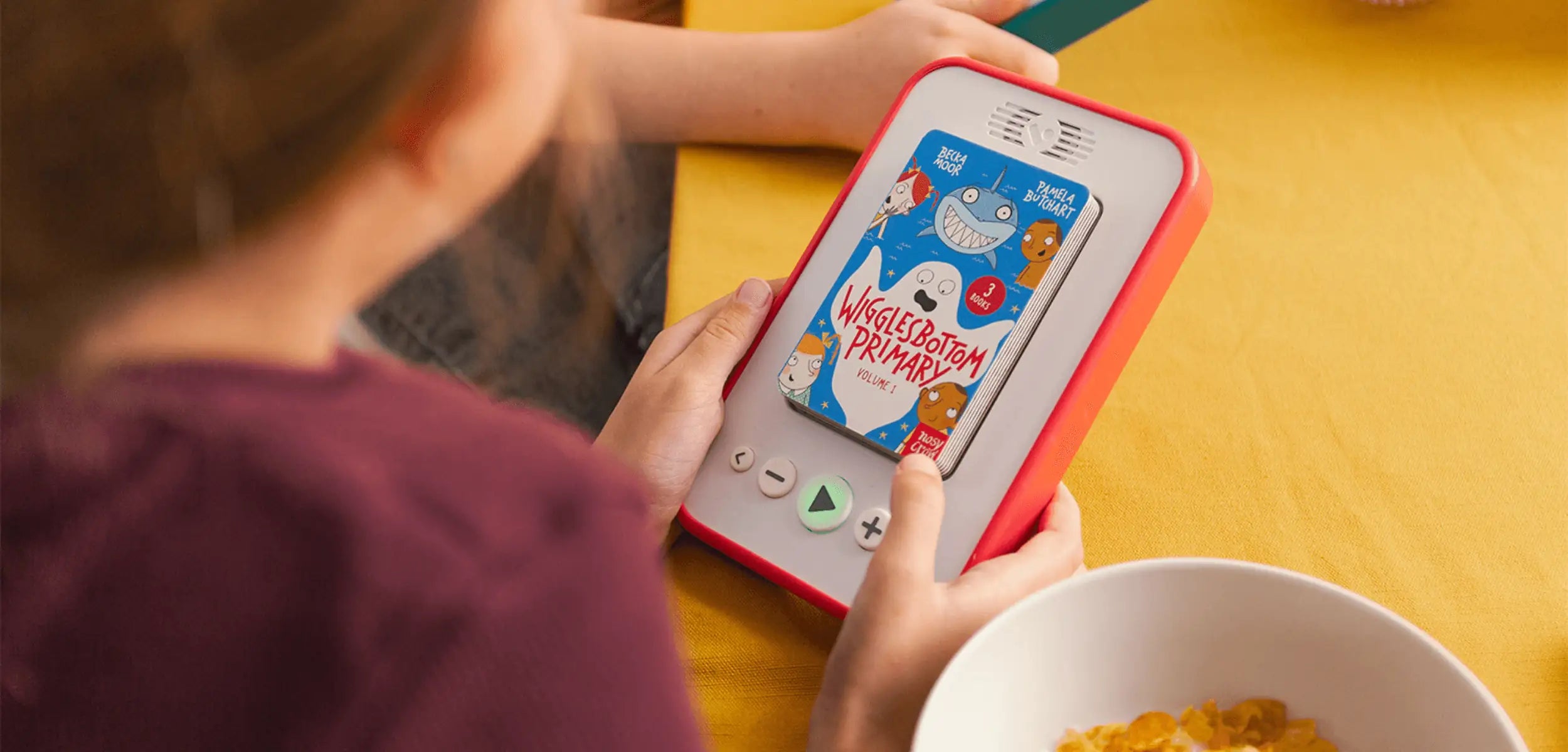 Person using a red audiobook player on a yellow table.