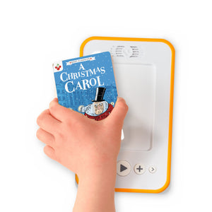 A hand holding the audiobook card for A Christmas Carol beside a Voxblock audiobook player