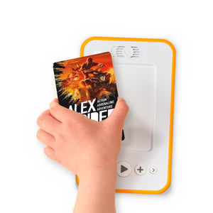 A hand holding the audiobook card for Alex Rider: Stormbreaker beside a Voxblock audiobook player