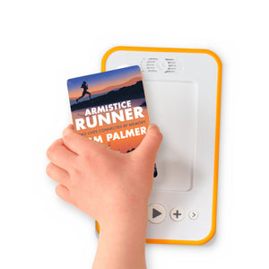 A hand holding the audiobook card for Armistice Runner beside a Voxblock audiobook player