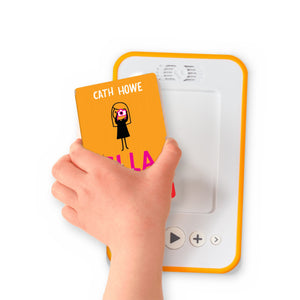 A hand holding the audiobook card for Ella on the Outside beside a Voxblock audiobook player