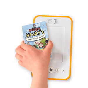 A hand holding the audiobook card for Horrid Henry's Super School Stories beside a Voxblock audiobook player