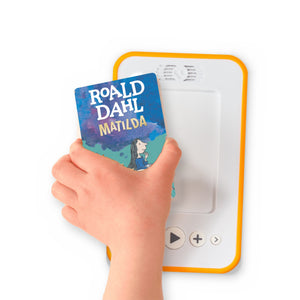 A hand holding the audiobook card for Matilda beside a Voxblock audiobook player