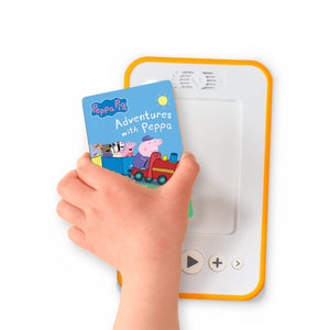 A hand holding the audiobook card for Peppa Pig: Adventures With Peppa beside a Voxblock audiobook player