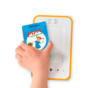 A hand holding the audiobook card for Pippi Longstocking Goes Aboard beside a Voxblock audiobook player