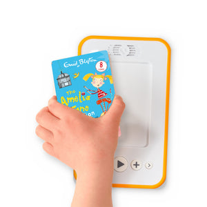 A hand holding the audiobook card for The Amelia Jane Collection beside a Voxblock audiobook player