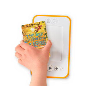 A hand holding the audiobook card for The Boy Who Flew With Dragons beside a Voxblock audiobook player