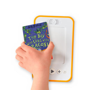 A hand holding the audiobook card for The Boy Who Sang with Dragons beside a Voxblock audiobook player
