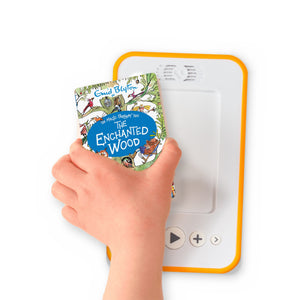 A hand holding the audiobook card for The Enchanted Wood beside a Voxblock audiobook player