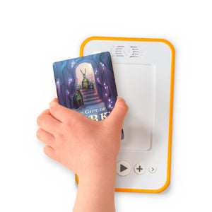 A hand holding the audiobook card for The Five Realms: The Gift of Dark Hollow beside a Voxblock audiobook player