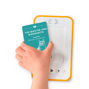 A hand holding the audiobook card for The Master and Margarita beside a Voxblock audiobook player