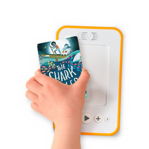 A hand holding the audiobook card for The Shark Caller beside a Voxblock audiobook player