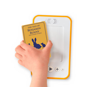 A hand holding the audiobook card for The Tale of Benjamin Bunny and Other Stories beside a Voxblock audiobook player