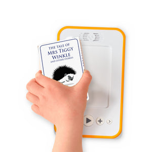 A hand holding the audiobook card for The Tale of Mrs Tiggy Winkle and Other Stories beside a Voxblock audiobook player
