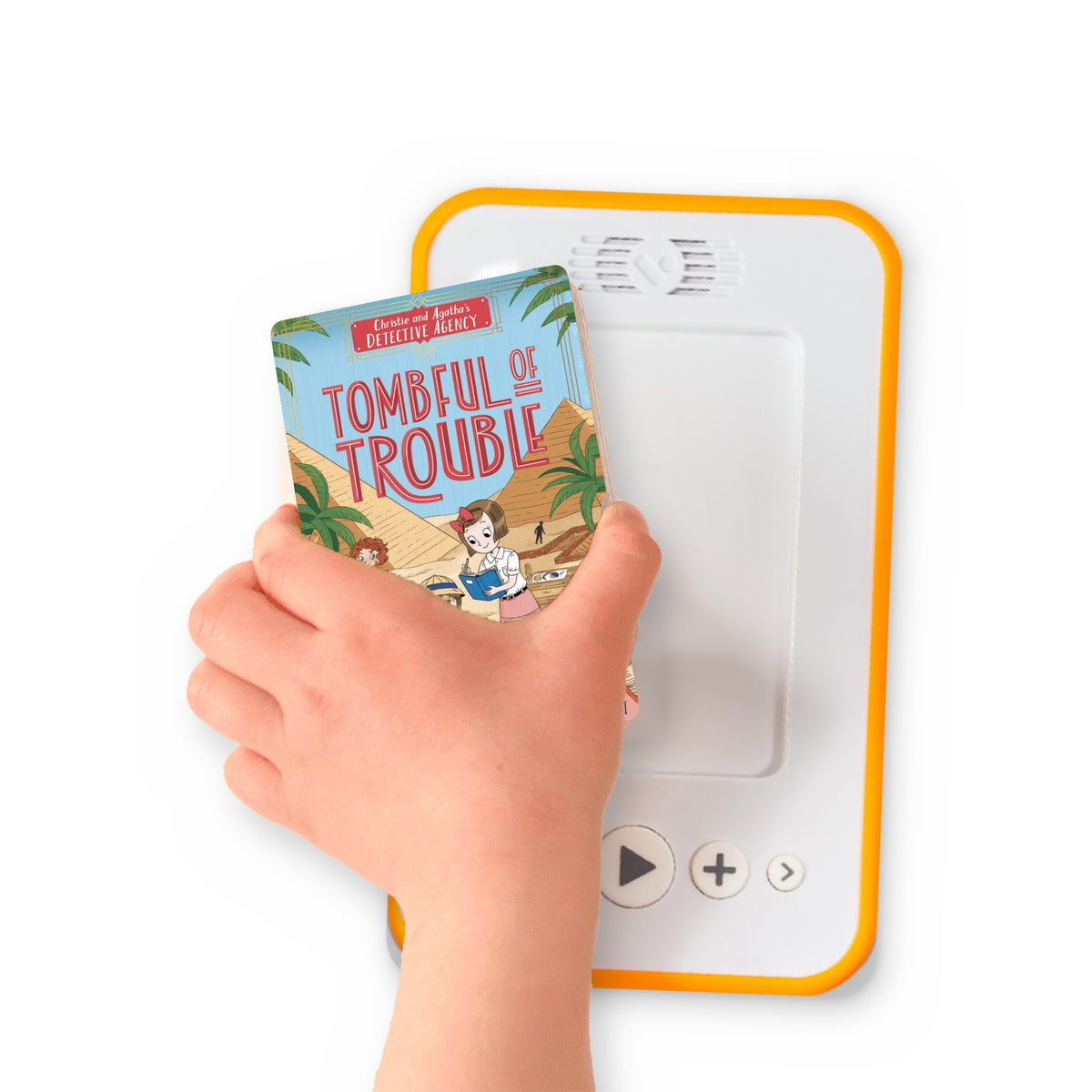 A hand holding the audiobook card for Tombful of Trouble beside a Voxblock audiobook player