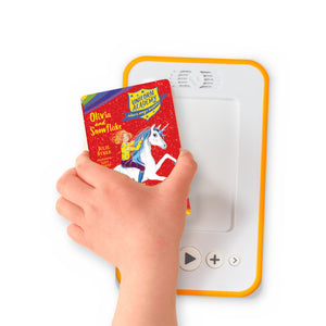 A hand holding the audiobook card for Unicorn Academy: Olivia and Snowflake beside a Voxblock audiobook player
