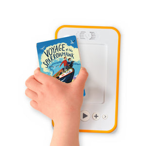 A hand holding the audiobook card for Voyage of the Sparrowhawk beside a Voxblock audiobook player