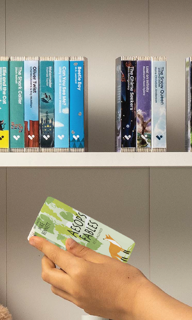 A hand taking the Aesop's Fables Reimagined audiobook from a shelf of Voxblock audiobooks