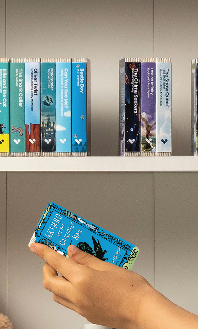 A hand taking the Akimbo and the Crocodile Man audiobook from a shelf of Voxblock audiobooks