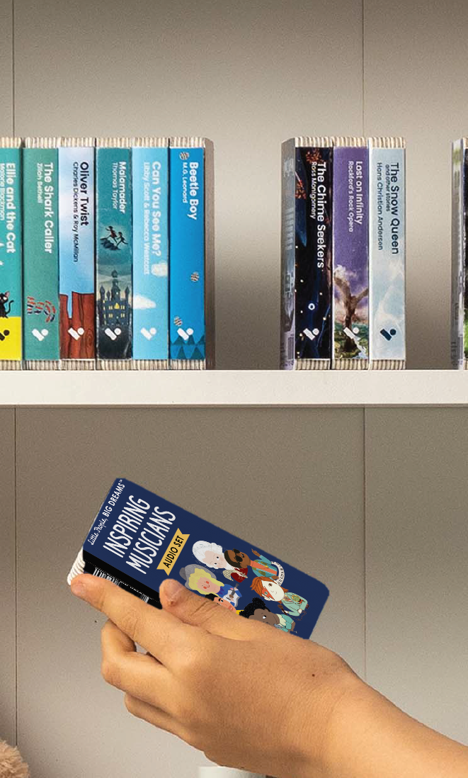 A hand taking the Little People Big Dreams: Inspiring Musicians audiobook from a shelf of Voxblock audiobooks