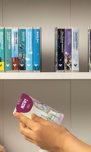 A hand taking the My First Mozart Album audiobook from a shelf of Voxblock audiobooks