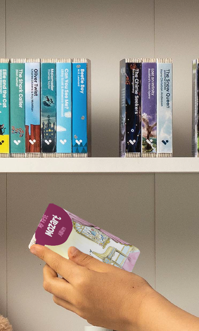 A hand taking the My First Mozart Album audiobook from a shelf of Voxblock audiobooks