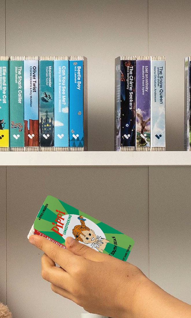 A hand taking the Pippi Longstocking in the South Seas audiobook from a shelf of Voxblock audiobooks
