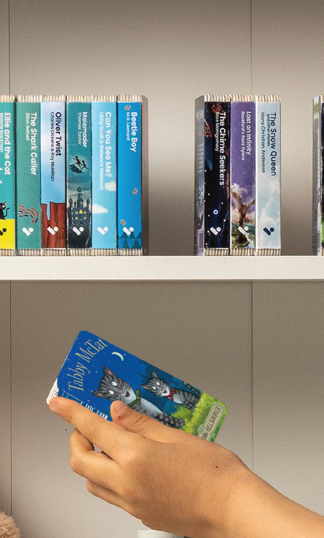 A hand taking the Tabby McTat audiobook from a shelf of Voxblock audiobooks