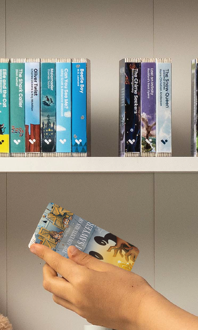 A hand taking The Adventures of Tom Sawyer audiobook from a shelf of Voxblock audiobooks