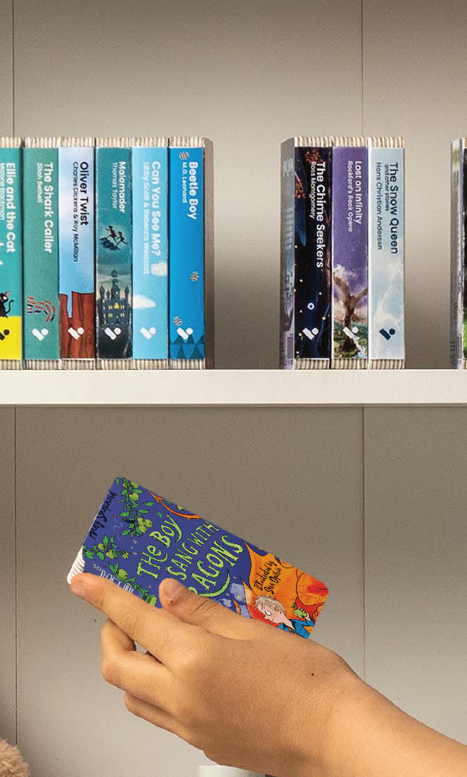 A hand taking The Boy Who Sang with Dragons audiobook from a shelf of Voxblock audiobooks
